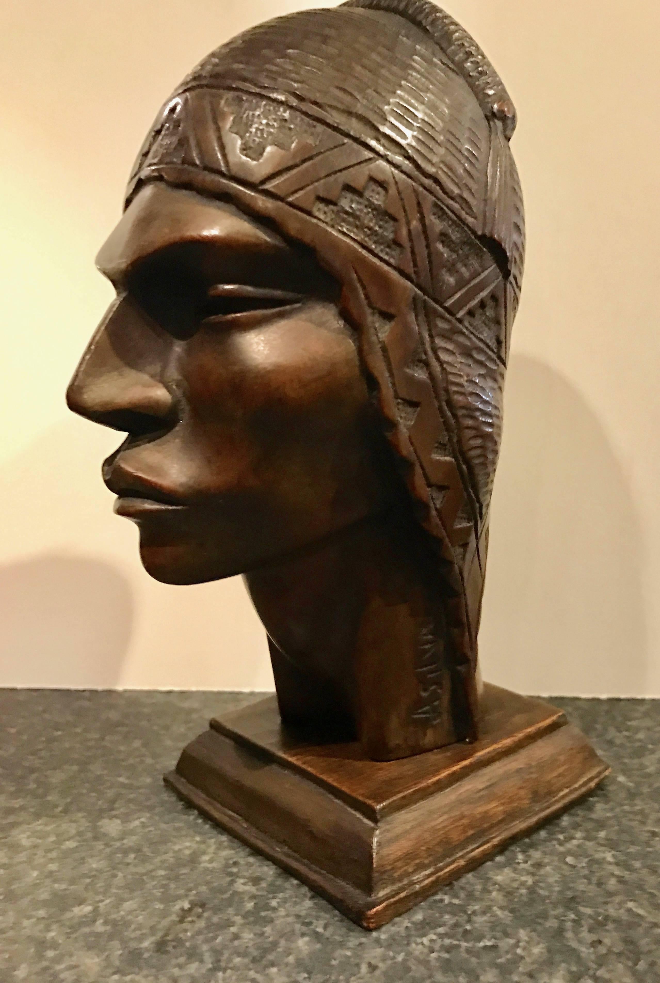 Original wood carved Indian (maybe Peruvian) head in the Art Deco style. Lots of geometric and triangular details integrated within the head dress. Interesting history I imagine, the face characteristics seem to be from a South American Indian