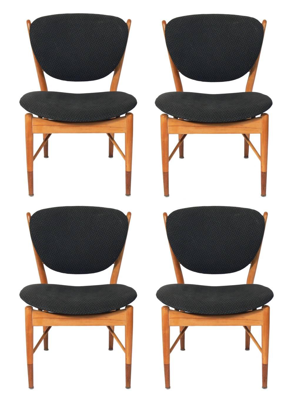Danish modern dining table and four dining chairs, designed by Finn Juhl for Baker, circa 1950s. Signed with Baker tag underneath. Very sculptural chairs and beautifully inlaid table. The table expands to an impressive length to fit up to ten