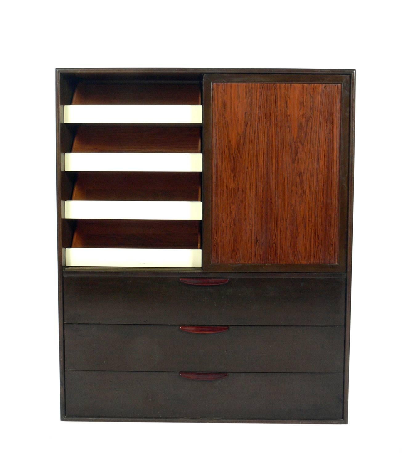 Tall rosewood chest of drawers or dresser, designed by Harvey Probber, American, circa 1960s. It offers a voluminous amount of storage. It features sliding doors at the top that open to reveal four deep drawers on the left, and three deep sliding
