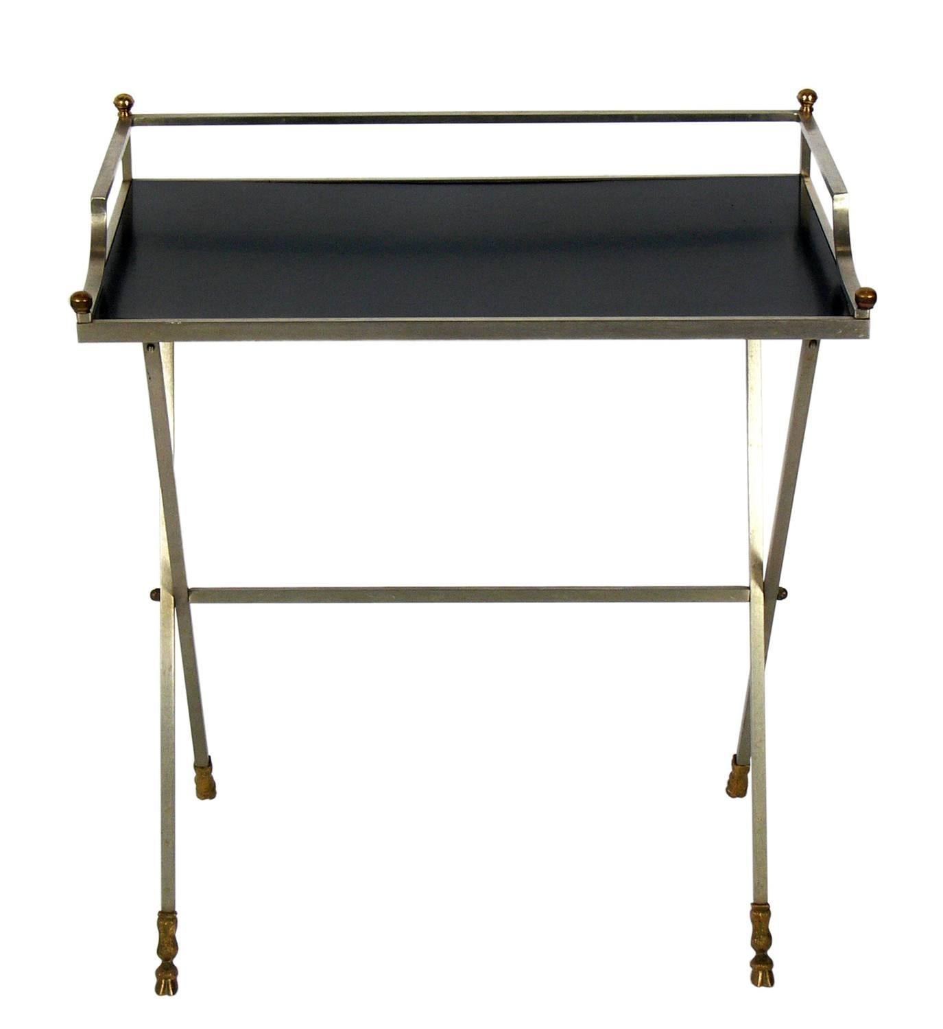 Elegant brushed steel and brass bar, in the manner of Maison Jansen, probably French, circa 1950s. This piece is a versatile size and can be used as a bar, desk, vanity, or console table. Low maintenance black laminate or micarta top.