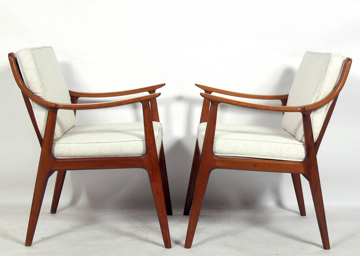 Pair of Danish modern lounge chairs attributed to Peter Hvidt & Orla Molgaard Nielsen, circa 1960s. They retain their original finish and caned backs, both with a warm original patina. Reupholstered in an ivory color herringbone upholstery.