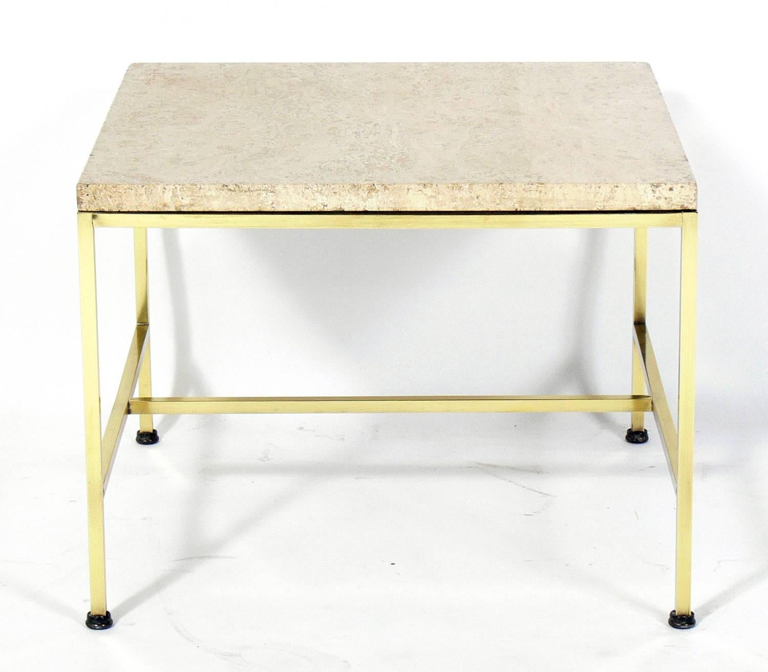 Brass and travertine side table, designed by Paul McCobb, American, circa 1950s. It is a versatile size and can be used as a side or end table, or as a nightstand. Brass frame has been polished and lacquered.