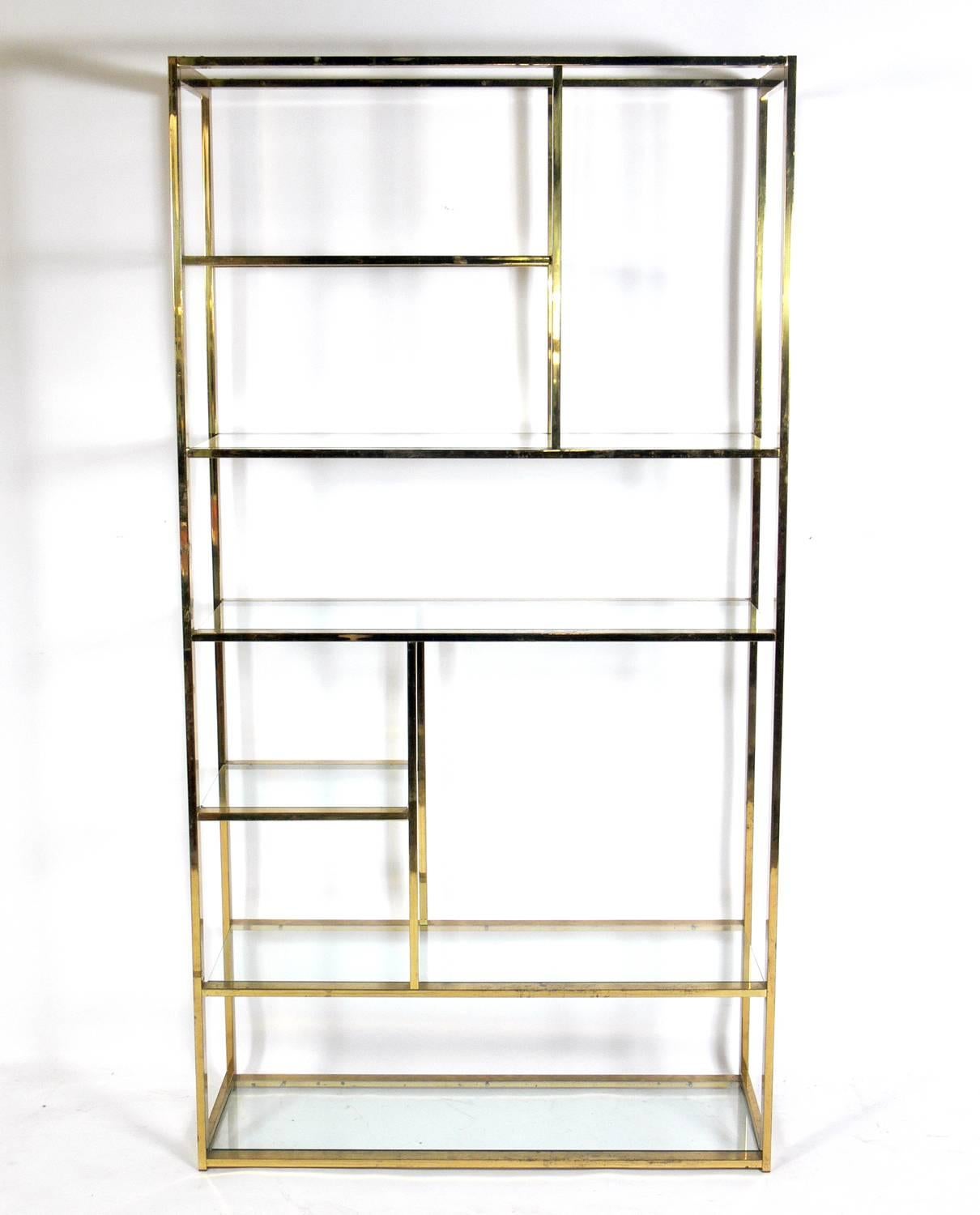 Brass étagère, bookshelf or vitrine, in the manner of Milo Baughman, American, circa 1960s. Retains warm original patina with age spotting and wear.