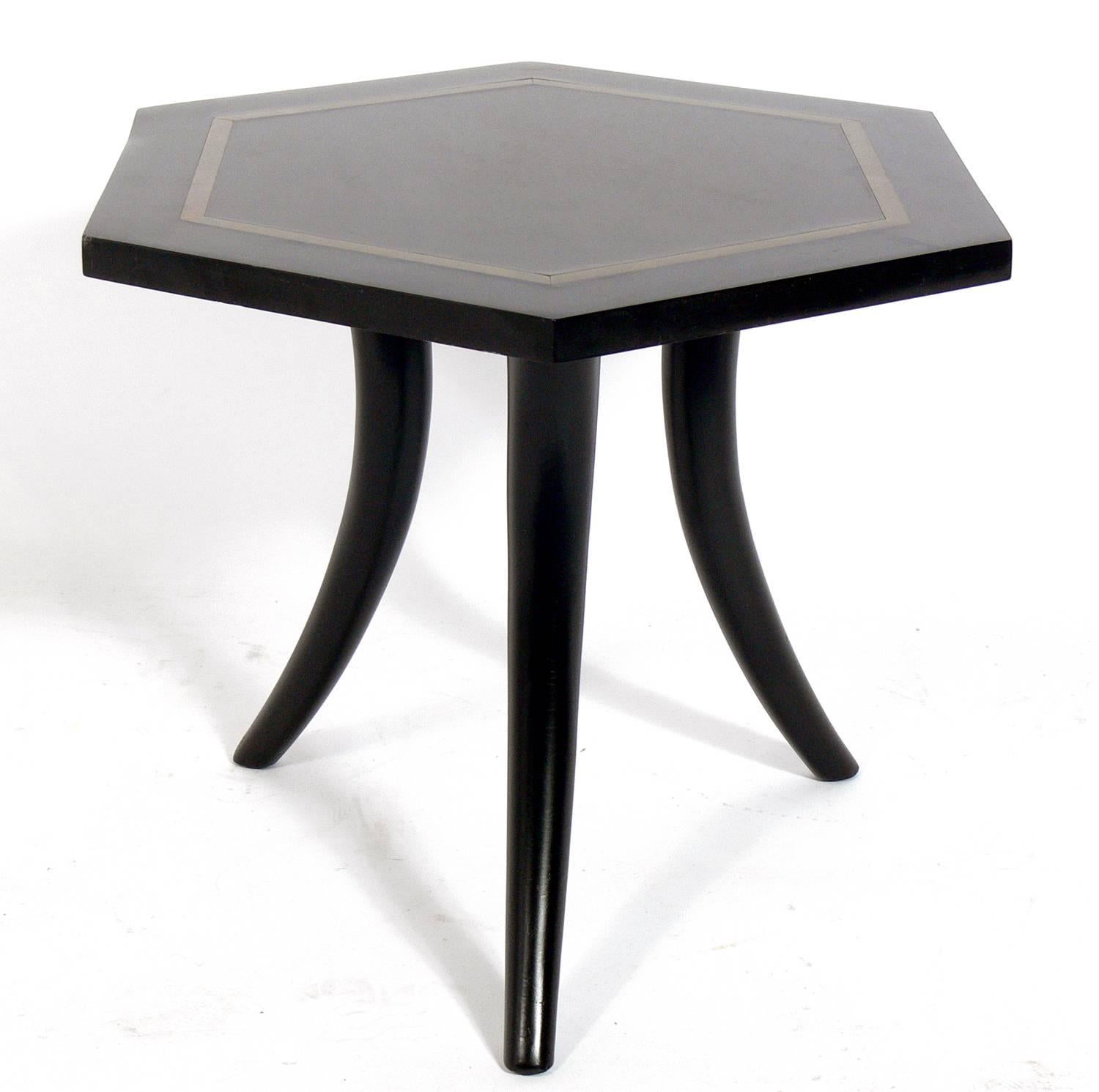 Brass Inlaid Tripod Table, American, circa 1950s. Very similar to designs by Harvey Probber or T.H. Robsjohn Gibbings. Curvaceous tusk legs have been refinished in black lacquer. The inlaid brass laminate top is low maintenance and perfect for a