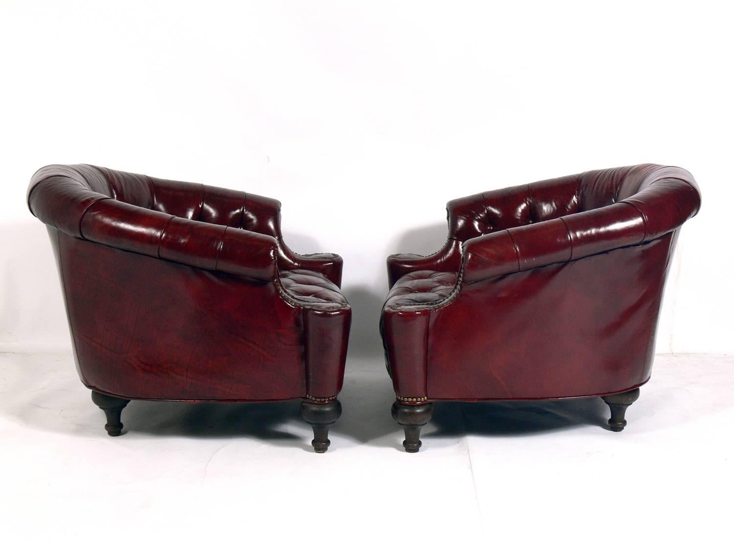 Pair of Tufted Oxblood Red Leather Club Chairs, probably English, circa 1940s. They have outstanding Chesterfield styling with deep tufting, brass tack details and a perfectly worn patina. 