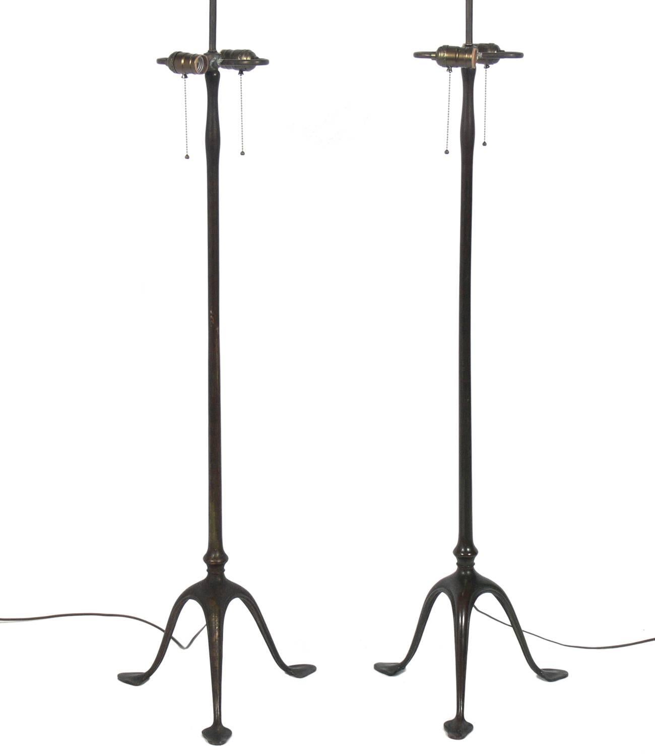 Patinated bronze floor lamps, designed for Tiffany Studios, American, circa early 1900s. They retain their warm original patina. We have always loved the sculptural bronze forms of these lamps and the addition of crisp paper shades give them a