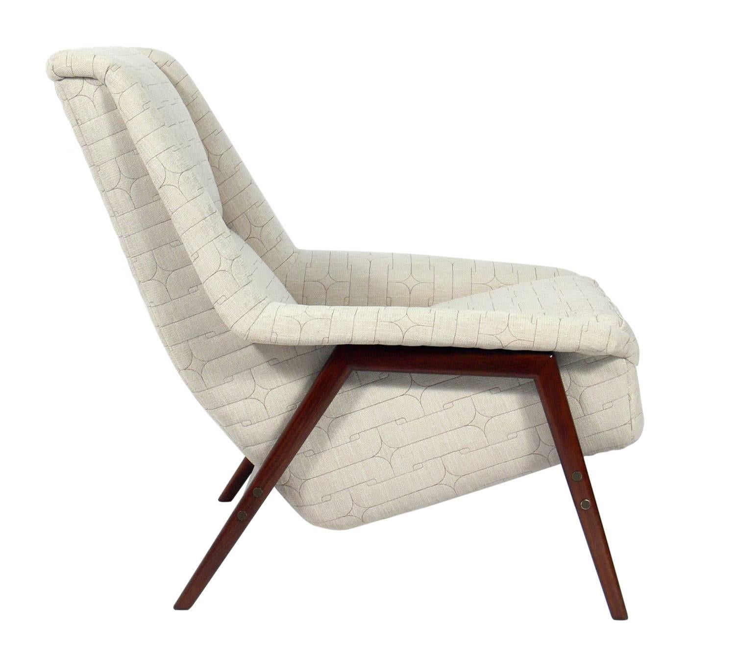 Danish modern lounge chair, designed by Folke Ohlsson, circa 1960s. This chair has been refinished and reupholstered in a channelled fabric. This curvaceous chair looks great from any angle and is very comfortable.