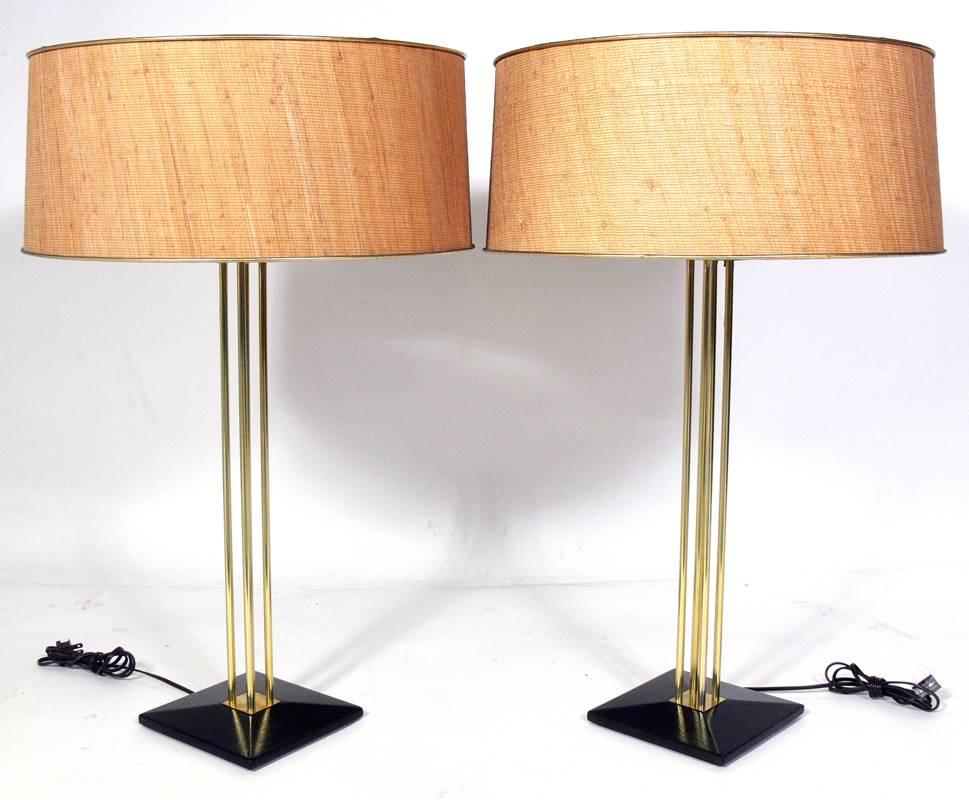 Pair of Brass and Grasscloth Shaded Table Lamps by Gerald Thurston, American, circa 1950's. They retain their original grasscloth shades and brass finials. The bases have been refinished in an ultra-deep brown lacquer and the brass fittings have