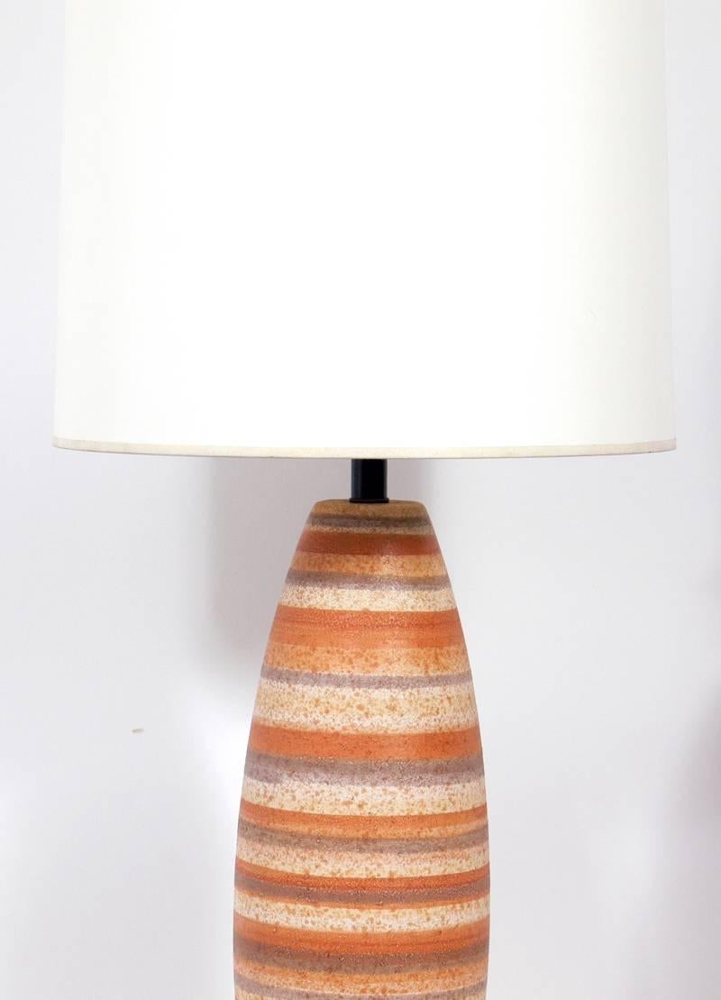 Pair of Mid Century Modern Ceramic Lamps in a Sandstone Strata, American, circa 1950's. Great sandstone colors. The wood bases and metal hardware have been refinished in an ultra deep brown lacquer. Rewired and ready to use. As they are unique