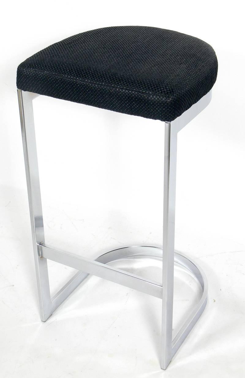 Set of Four Chrome Bar Stools in the manner of Milo Baughman, American, circa 1960's. They are a versatile size and can be used as bar stools or as kitchen counter stools. The current fabric needs to be reupholstered. The price noted below INCLUDES