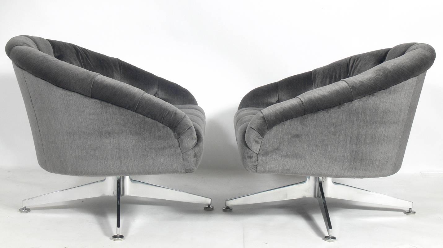 Pair of charcoal gray velvet swivel lounge chairs designed by Ward Bennett, American, circa 1960s. They have been completely restored in charcoal gray velvet and the aluminum bases have been polished.