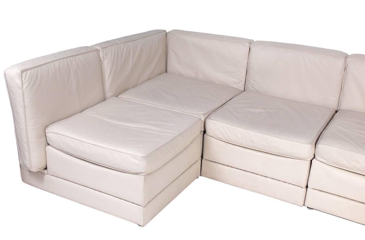 Low slung sectional sofa, designed by Milo Baughman for Thayer Coggin, American, circa 1970s. It retains it's original bone color leather upholstery, It consists of six pieces(two corner chairs and four slipper chairs) which can be configured in