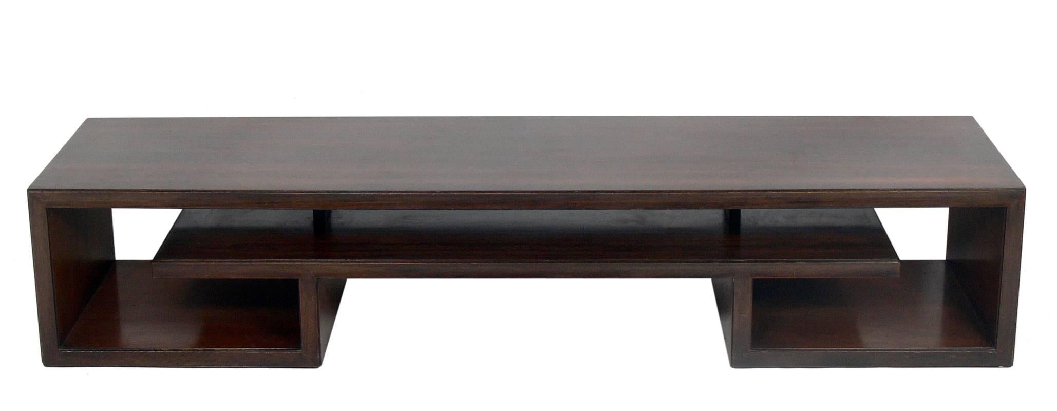 Asian Form Rosewood Coffee Table or Bench, designed by Paul Frankl for Johnson Furniture, American, circa 1950's. It exhibits an elegant Asian scroll design with beautifully grained rosewood. It is a versatile size and can be used as a coffee table