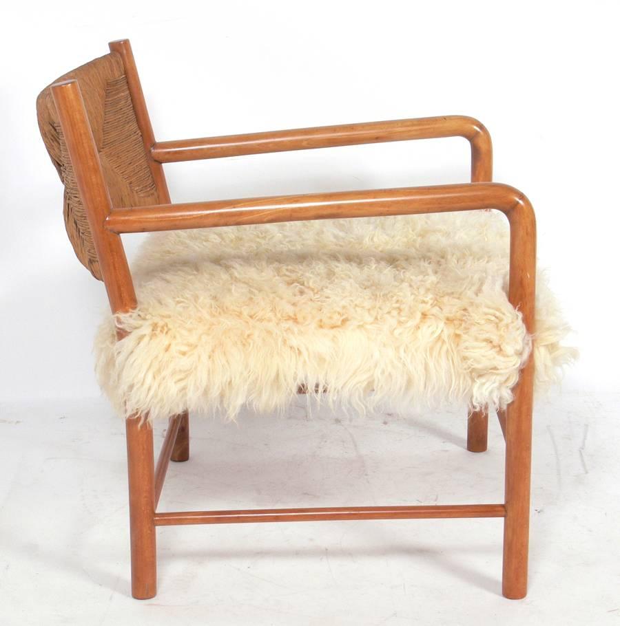 Mid Century Modern Lounge Chair, Italy, circa 1950's. Executed in a woven paper cord with a sheepskin seat. Branded mark underneath 