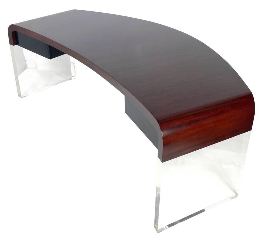 Curvaceous rosewood and Lucite desk, designed by Vladimir Kagan, American, circa 1960s. This model is documented in the book 