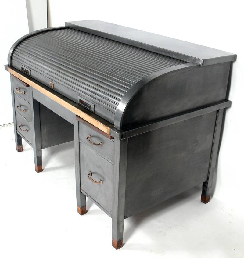 Banker's metal roll top Industrial desk, probably made by the Art Metal Company, American, circa 1930s. It exhibits an outstanding Machine Age design and is executed in steel, brass and leather. It offers a voluminous amount of storage with five