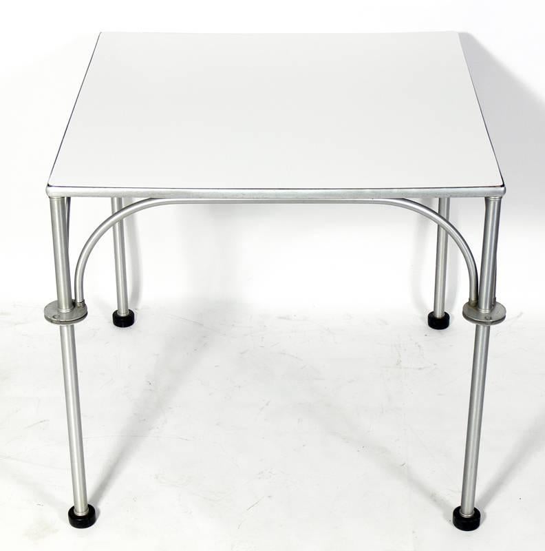 Art Deco aluminium dining or game table, designed by Warren McArthur, circa 1930s. Executed in aluminium with a low maintenance white laminate top and retaining it's original black rubber feet. Please see our other 1stdibs listings for Warren.