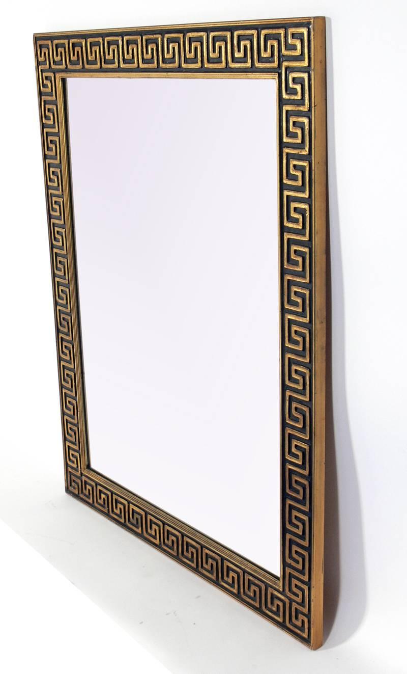Elegant gold leaf and black Greek key mirror, American, circa 1960s. Retains a wonderful original patina to the gold leafed and black painted wood frame.