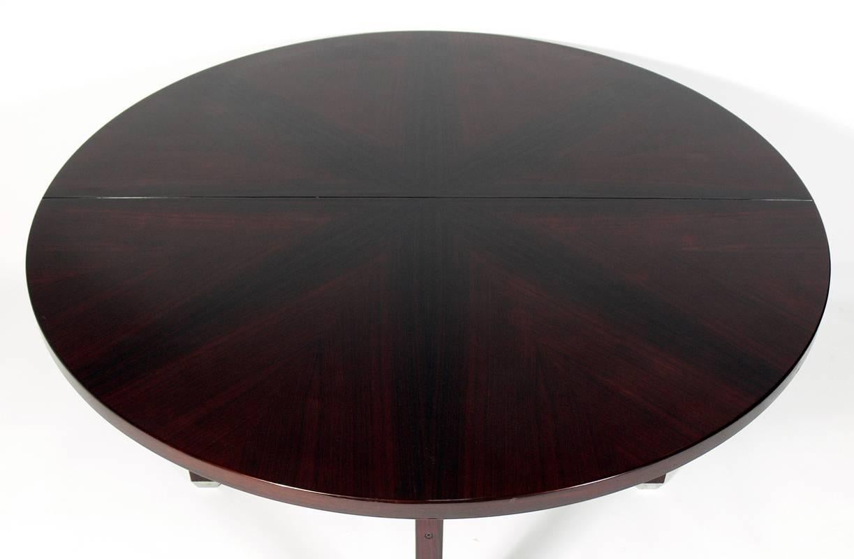 Rosewood dining table, designed by Ico Parisi for Mobili Italiani Moderni (MIM), Italy, circa 1960s. The table can seat four in it's closed round configuration, or it expands to seat eight with the leaf open. With the leaf open, the table measures