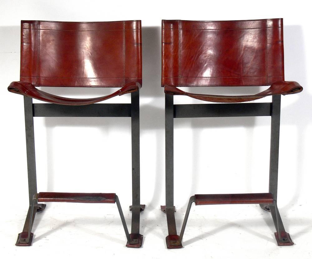 Pair of leather and steel bar stools, designed by Max Gottschalk, American, circa 1960s. Clean lined architectural form. Beautifully patinated original cognac leather seats, footrests and feet.