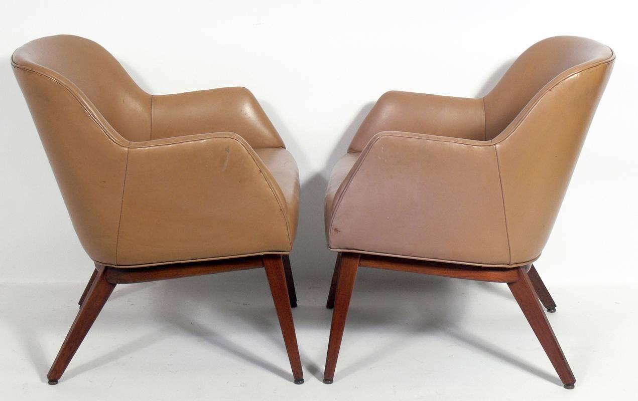 Pair of leather lounge chairs, designed by Jens Risom, circa 1950s. Signed with early Risom fabric tag underneath. They retain their original mushroom color leather upholstery. The original leather has some cracks, rubs, and wear. They can be used