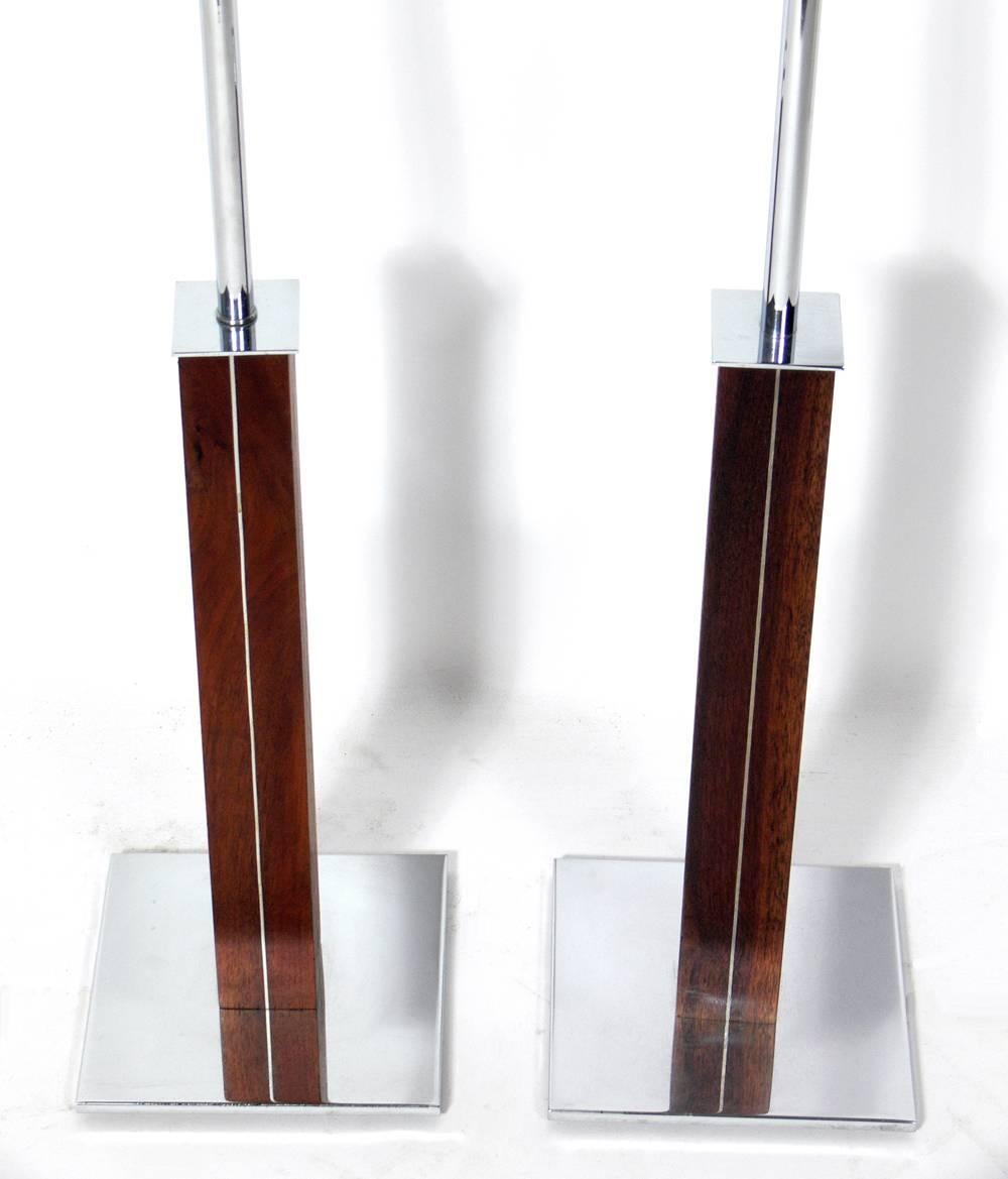 Pair of clean lined architectural lamps, designed by Walter Von Nessen, circa 1950s. They are very well constructed with sleek walnut shafts with inset chromed metal trim and bases. Rewired and ready to use. Shades included.