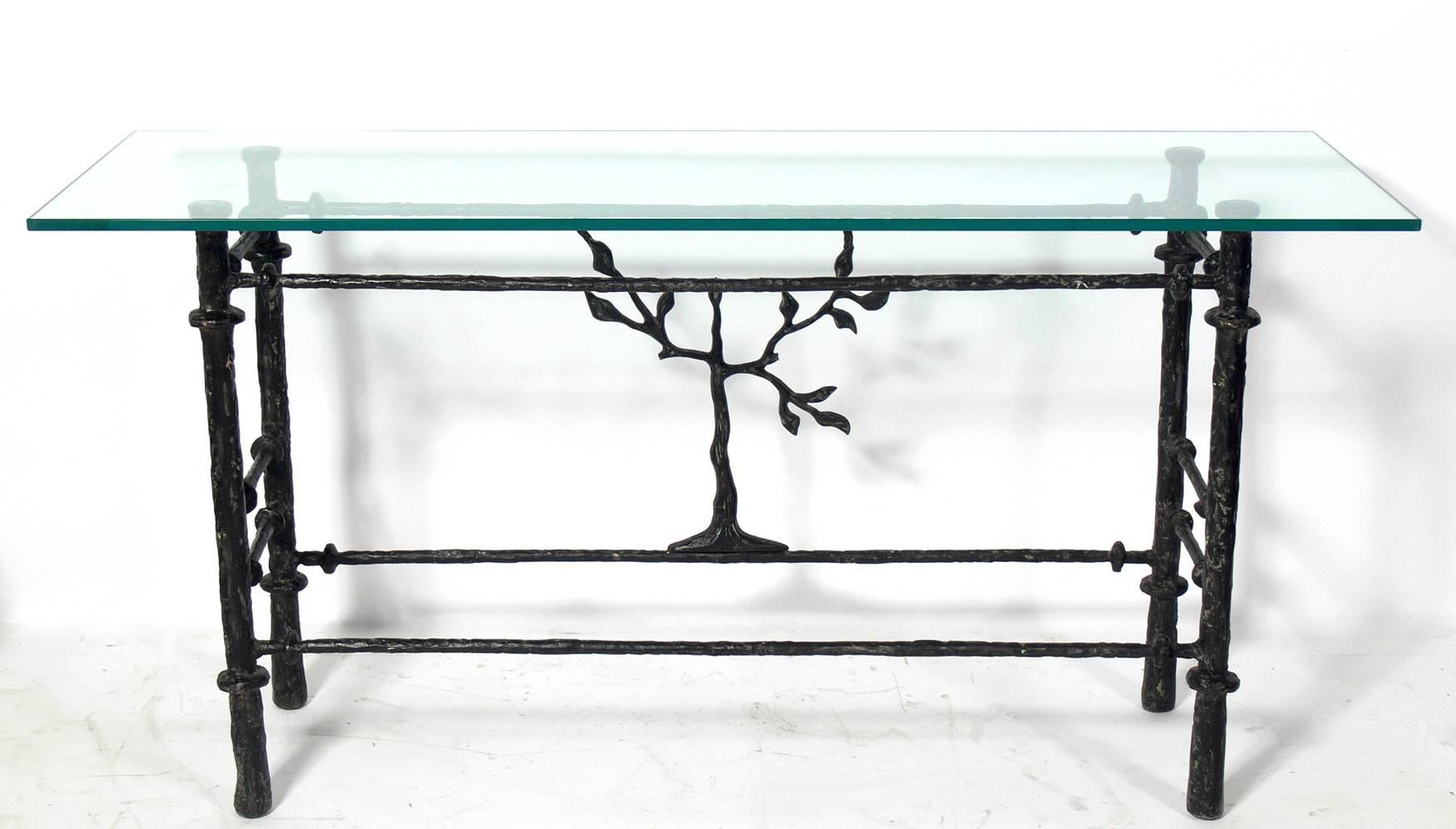 Sculptural console table in the manner of Diego Giacometti, circa 1980s.
This low slung table is a versatile size and can be used as a console table, bar, or sofa table. It is constructed of bronze patinated metal with a glass top.