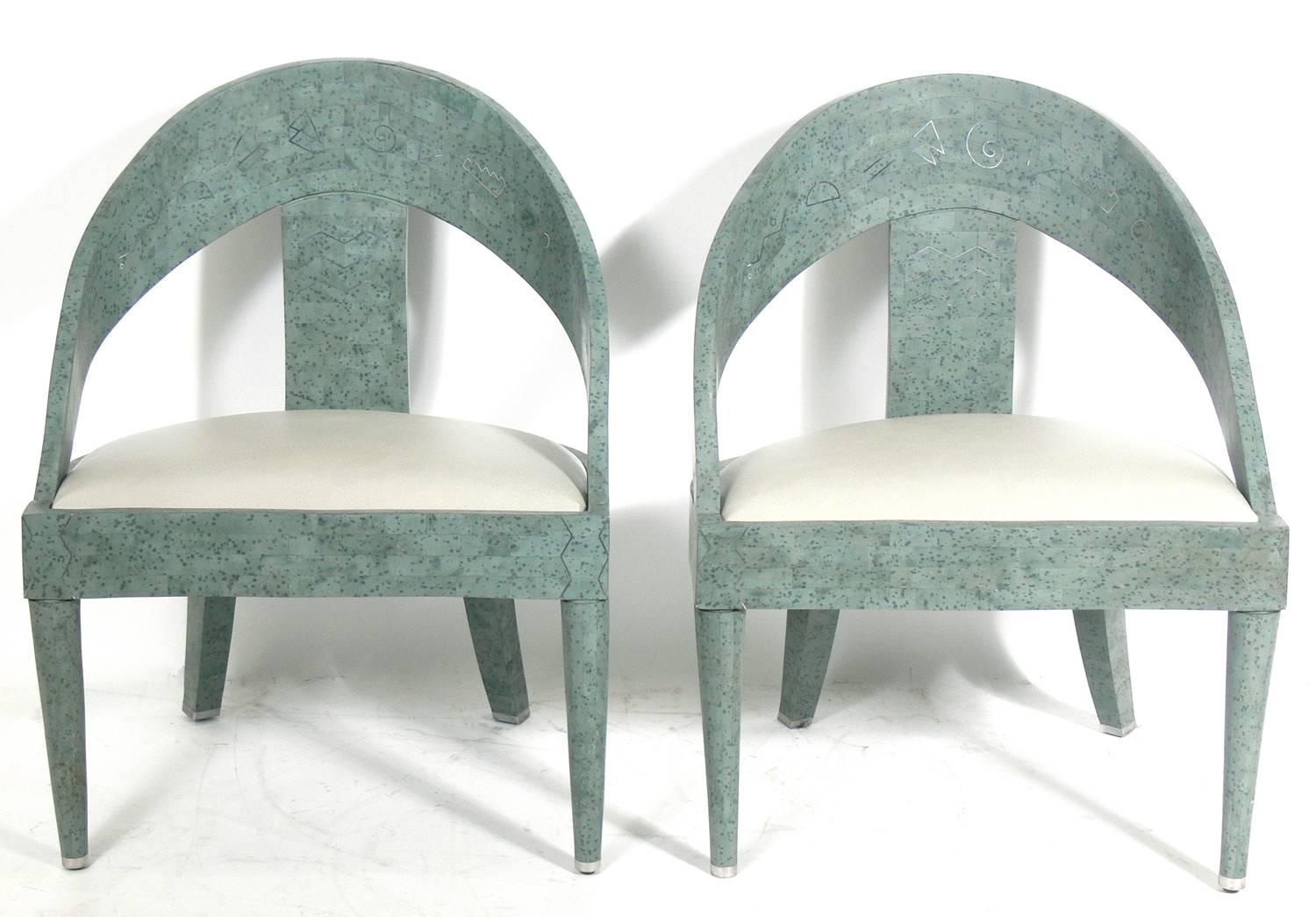 Pair of tessellated lounge chairs with silver inlay, American, circa 1980s. They are believed to be constructed of tessellated horn with a mottled green finish and silver inlaid designs. They have been reupholstered in a gray Edelman leather.