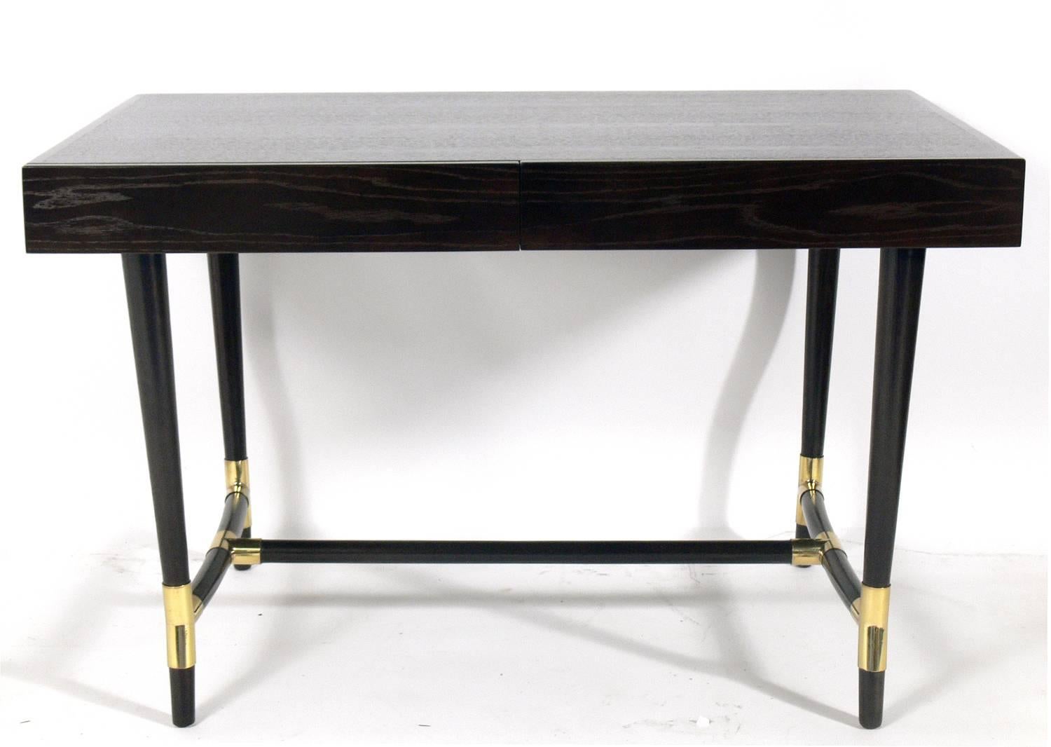 Elegant ebonized and brass desk, American, circa 1960s. This piece has been completely restored in an ultra-deep brown (almost black) finish with the brass elements hand polished and lacquered.
It is a versatile size and can be used as a desk,
