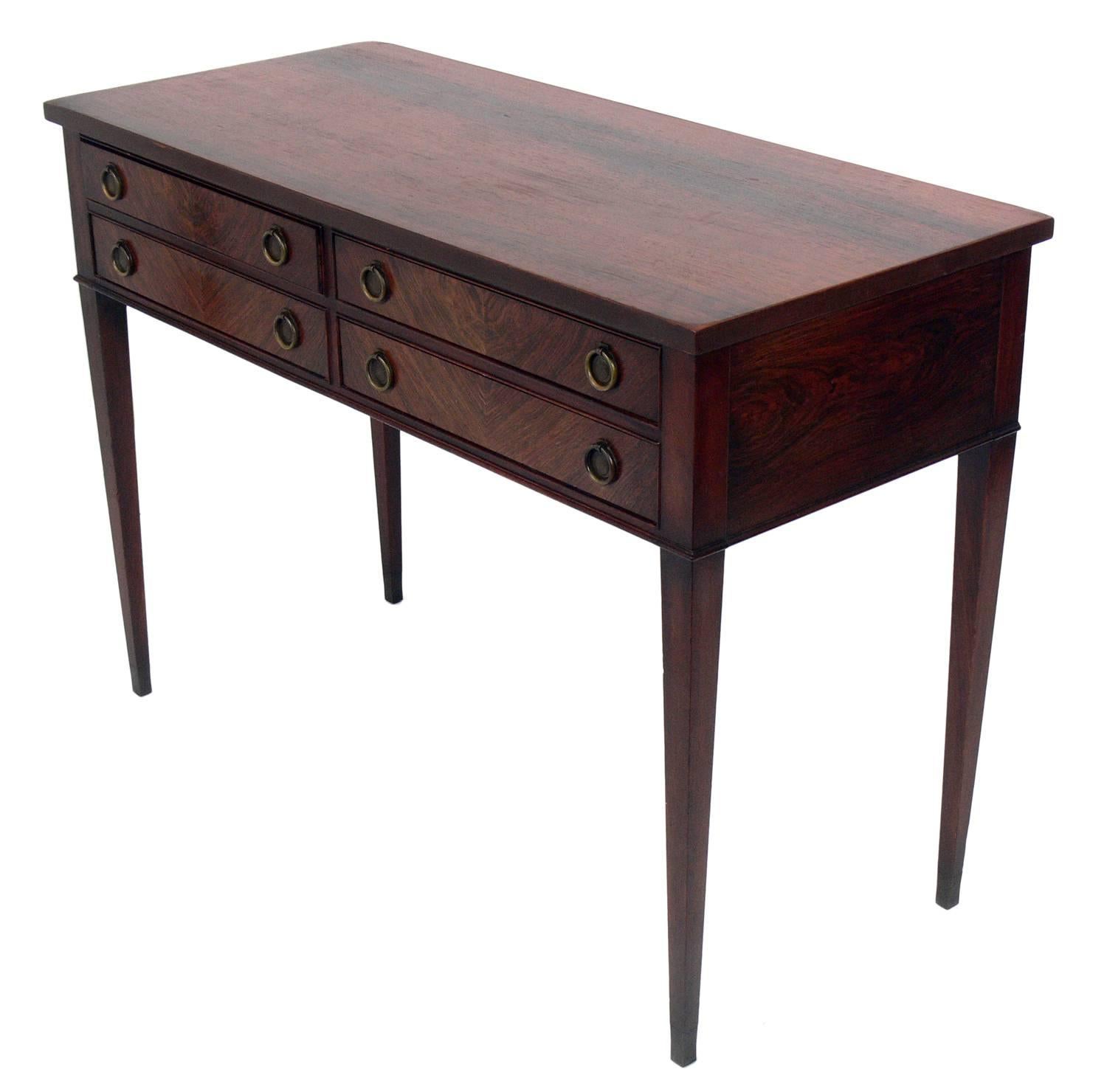 Clean lined Danish modern rosewood console, Denmark, circa 1940s-1950s. This piece is constructed of rosewood and possibly teak and retains it's original patinated brass hardware. It is a versatile size and would work well as a console table, desk,