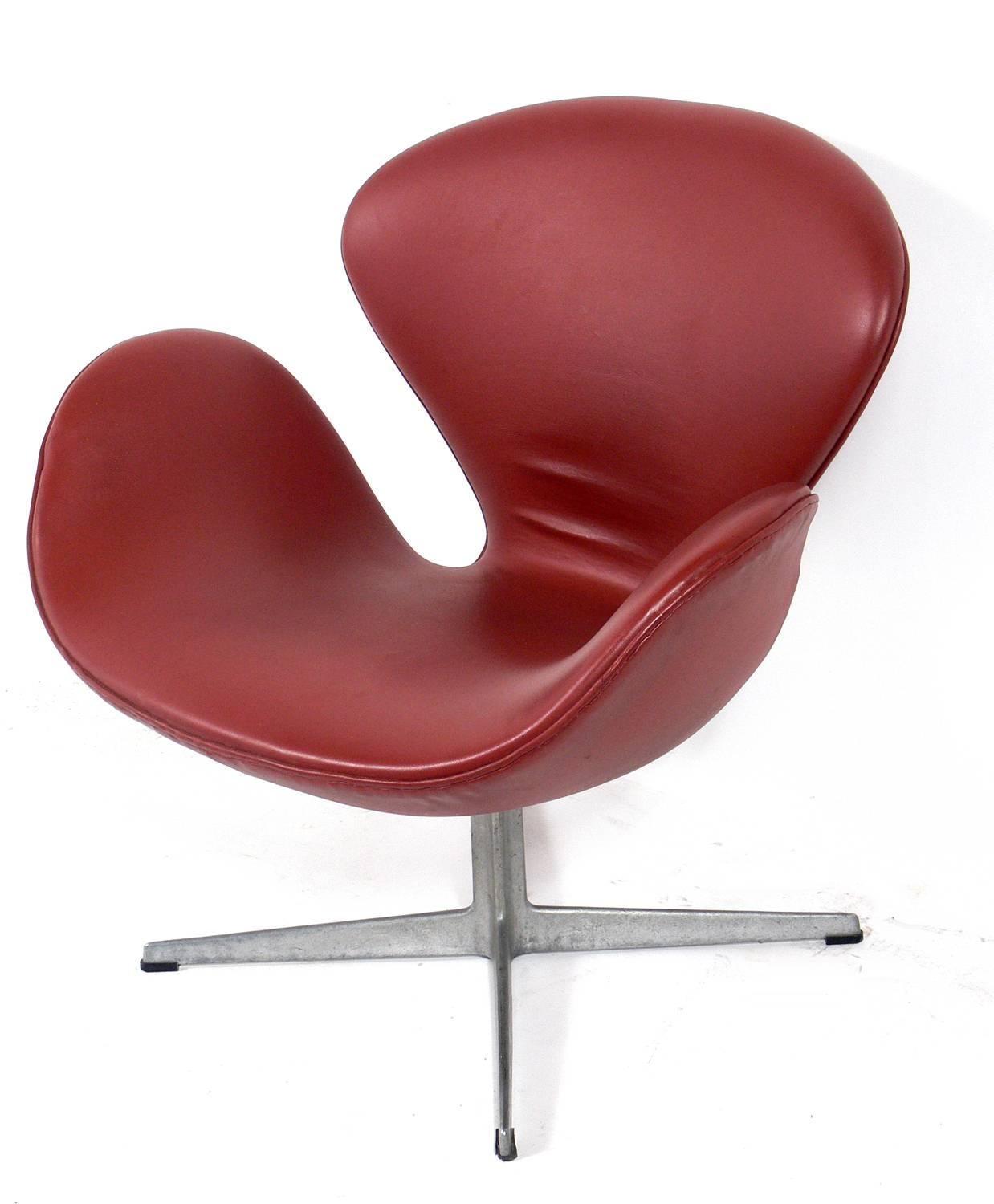 Sculptural swan chair, designed by Arne Jacobsen for Fritz Hansen, Denmark, circa 1960s. It retains it's original cognac color vinyl upholstery. Super low maintenance and easy to clean. Iconic Danish modern design.