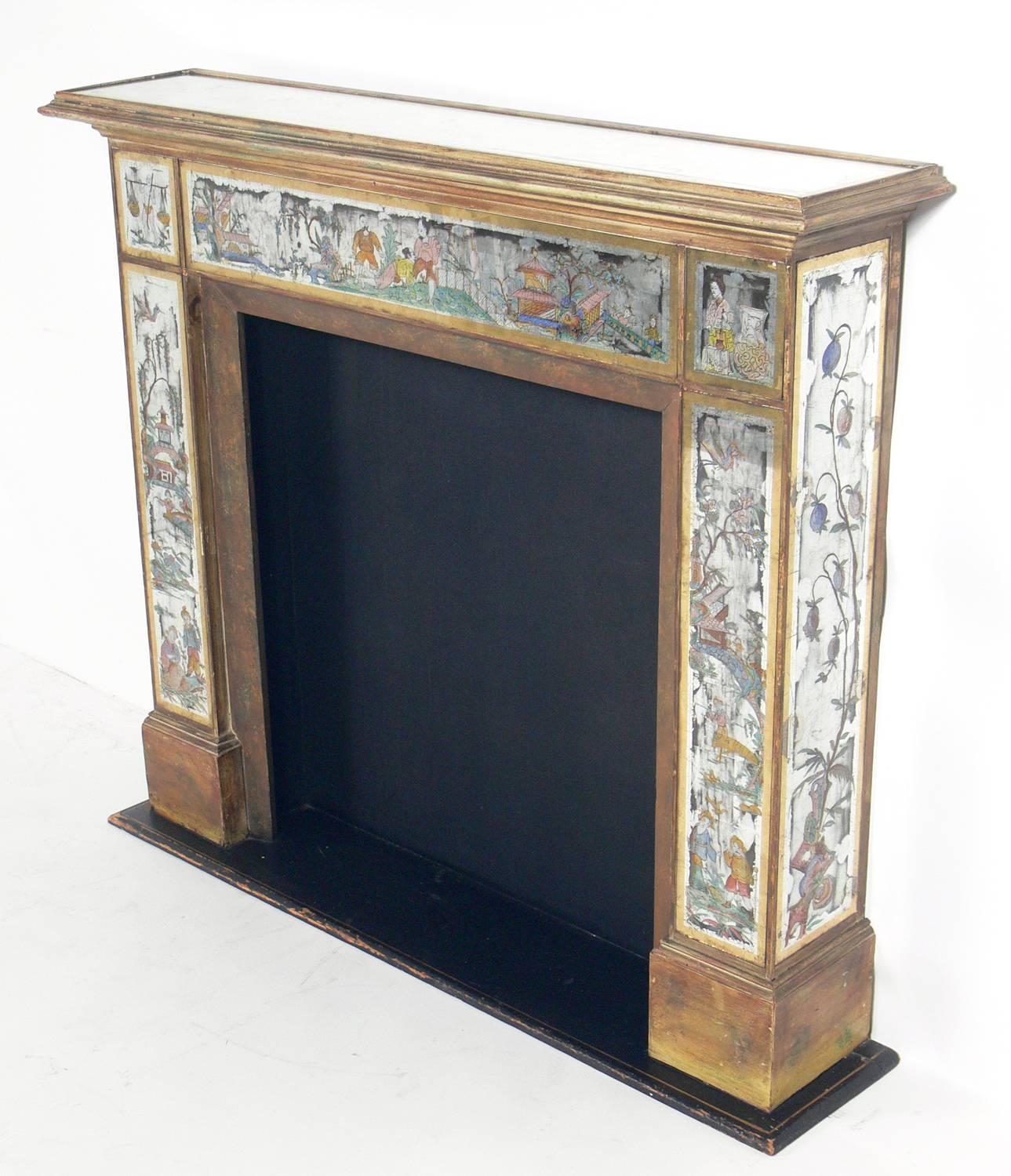 Hollywood Regency mirrored fireplace mantel with Asian églomisé Decoration, American, circa 1930s. This piece retains it's wonderful original patina to both the mirrored surfaces and the gilt woodwork. It was originally used with fake logs, but the