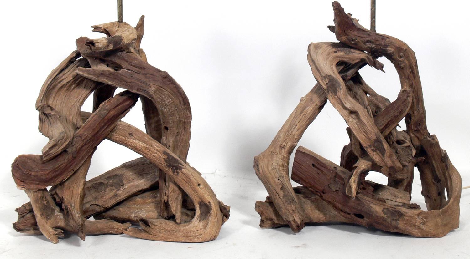 Pair of sculptural driftwood lamps, American, circa 1950s. They would be perfect in a beach house, or an interior with a nautical theme, or anywhere you need some organic sculptural forms. They retain their original driftwood finials. The price