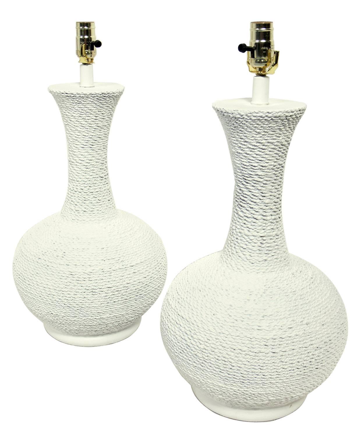 Pair of coiled rope plaster lamps, American, circa 1980s. They have a very nautical feel and a chalky white color finish. Rewired and ready to use.