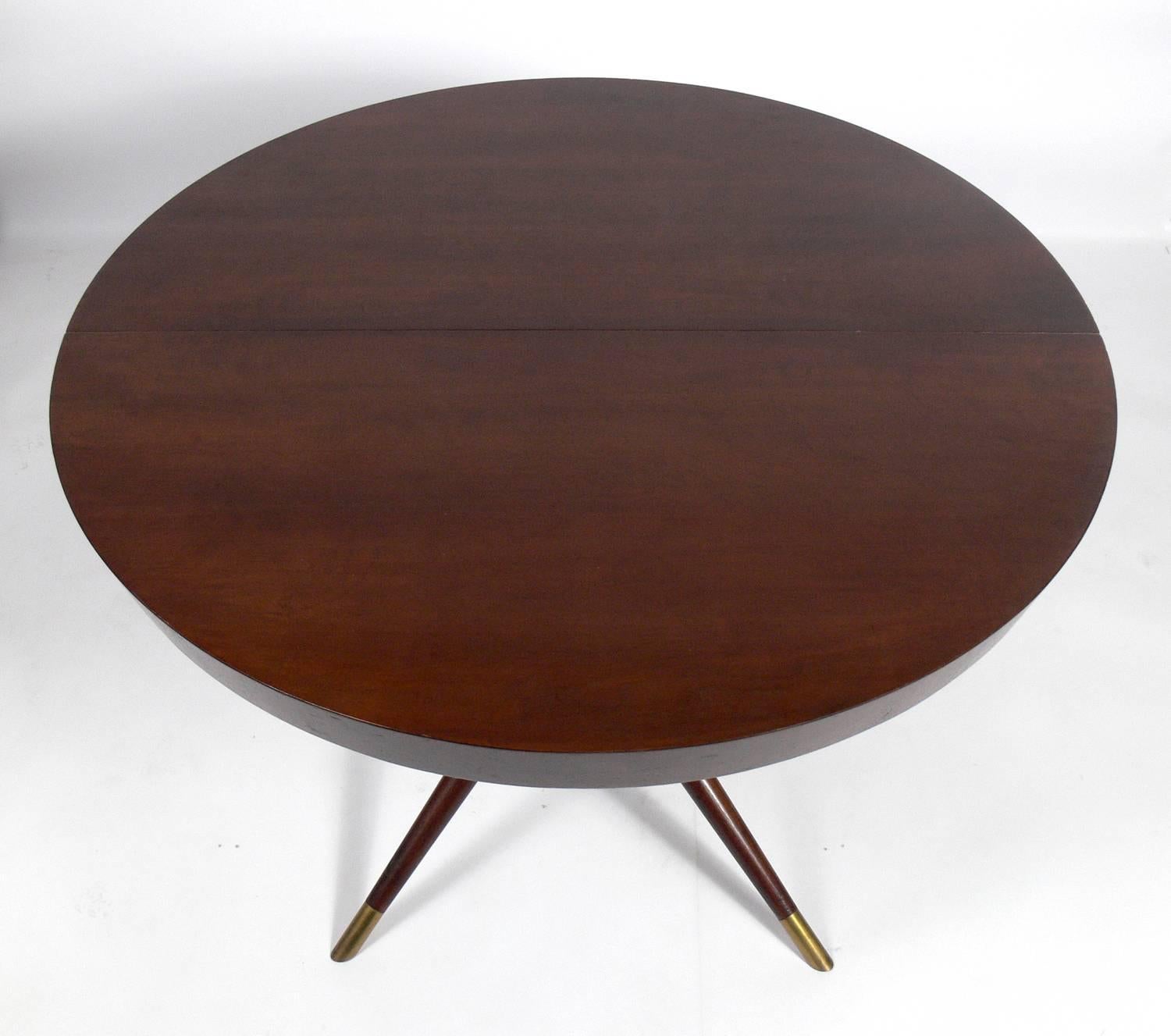 Incredible Italian dining table, circa 1950s. This table expands from it's round shape, seating to four to six people, to a large oval to accommodate up to ten guests. With it's three leaves installed it measures an impressive 98