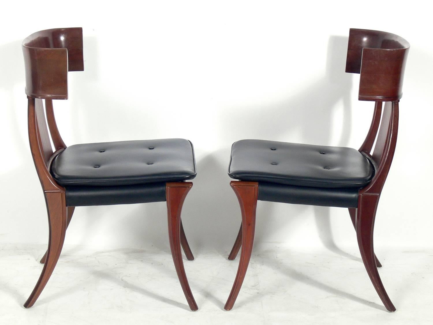 Pair of curvaceous walnut Klismos chairs, in the manner of T.H. Robsjohn Gibbings, American, circa 1960s. Gibbings was inspired by Classical Greek design. They retain their original black vinyl upholstery, or if you prefer, they can be reupholstered