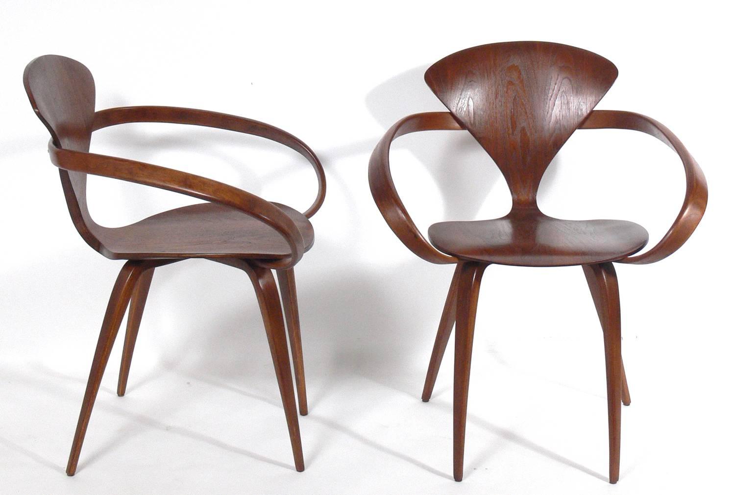 Set of 12 sculptural dining chairs, designed by Norman Cherner for Plycraft, circa 1950s. They have all been refinished and look great. The price noted below is for the set of 12 dining chairs, two armchairs and ten side chairs.