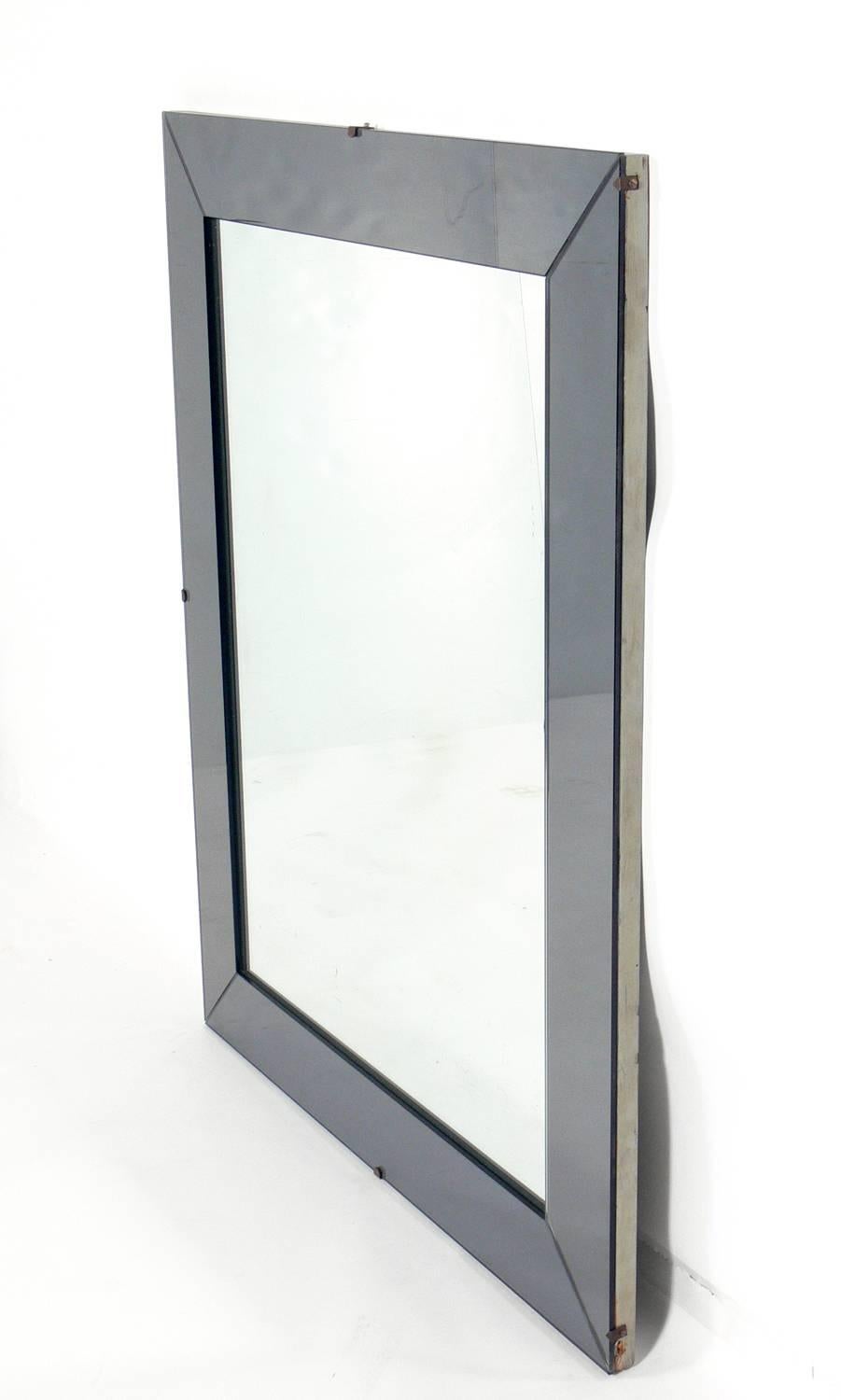 Elegant mirror in gun metal color mirrored glass frame, American, circa 1950s. It can be hung horizontally or vertically. Retains warm original patina to original mirrored glass.