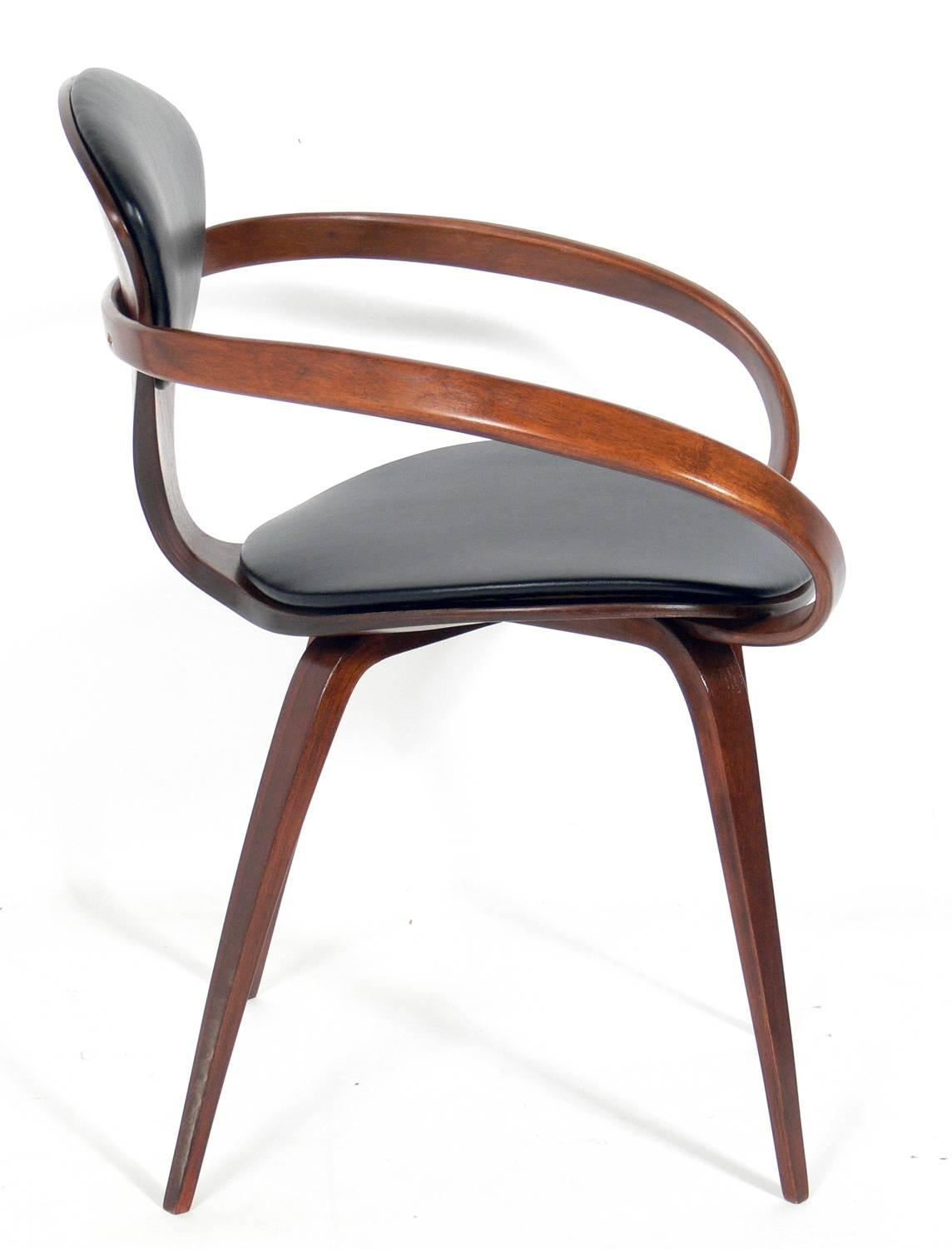 Set of 12 sculptural dining chairs, designed by Norman Cherner for Plycraft, American, circa 1950s. They have all been refinished and reupholstered in black vinyl. The side chairs measure 31