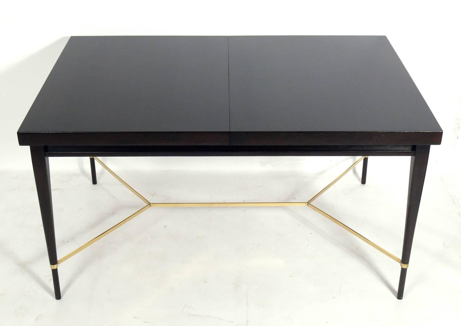 Paul McCobb modern dining table for Calvin, American, circa 1950s. It has been refinished in an ultra-deep brown color lacquer and the brass stretcher has been hand polished and lacquered. There are no additional leaves. Comfortably seats six.