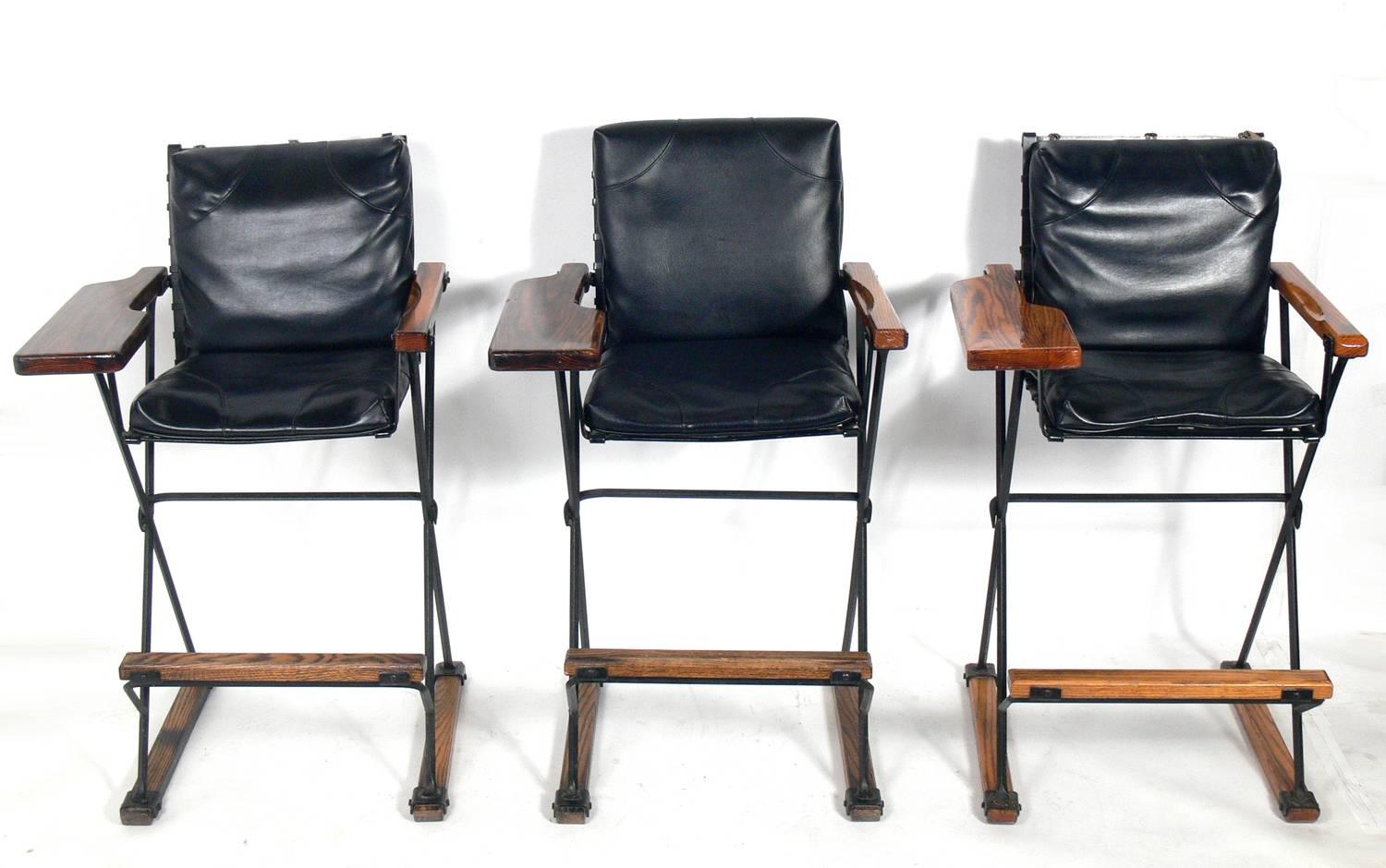 Elegant X-base oak and iron bar or billiard stools, designed by Cleo Baldon for Terra Furniture of California, American, circa 1960s. If you prefer, we can remove the wider billiard arm on the right and replace it with a bar stool arm to match the