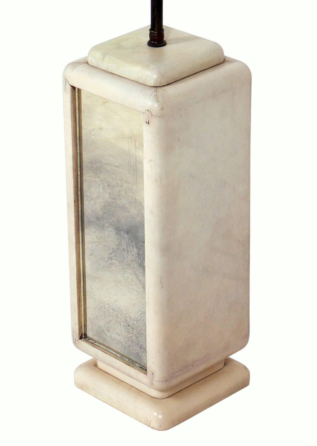 Lampe Hollywood Regency en cuir et miroir vieilli, américaine, vers les années 1940. Le cuir blanc d'origine s'est fondu en une chaude couleur ivoire. Recâblé et prêt à être utilisé