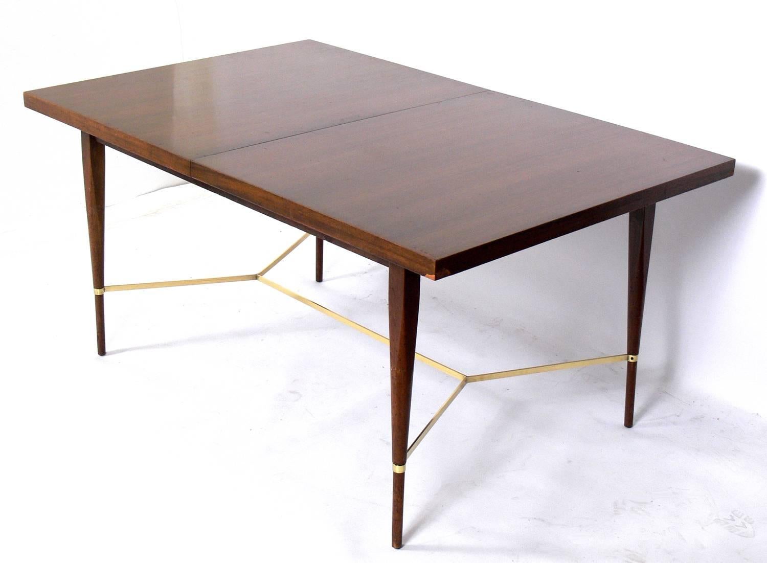 Modern dining table, designed by Paul McCobb for Calvin, American, circa 1950s. This table is currently being refinished, and can be completed in your choice of color. The price noted below inlcudes refinishing in your choice of color. The brass