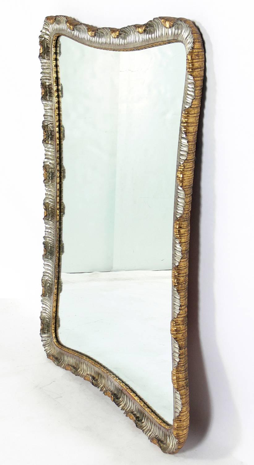 Venetian Scalloped Mirror, Italy, circa 1950's. Silver leaf gilt in the front and gold leaf gilt on the sides and back of the frame. Undulating curves of hand-carved and giltwood and gesso give this mirror it's elegant form. The original gilt finish