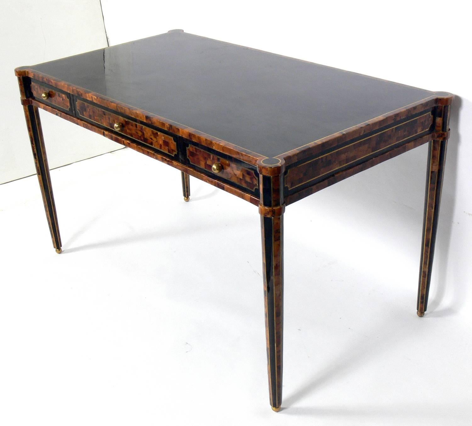Tessellated horn desk, designed for the Maitland Smith Company, circa 1980s. It is executed in lacquered tesselated horn with brass inlay over a wooden frame. It is a versatile size and will work well as a desk, vanity, or bar. Signed with Maitland