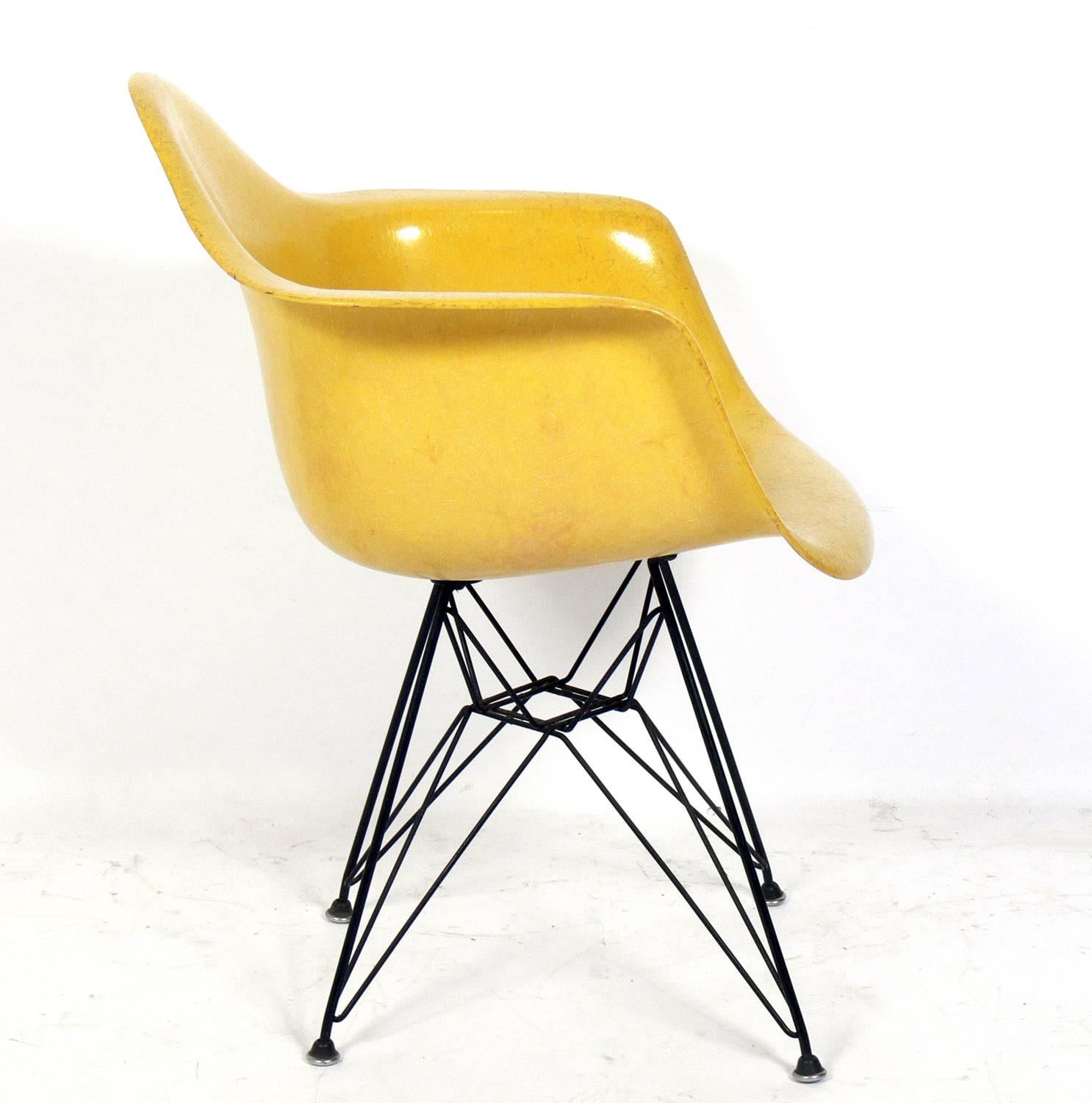 Early lemon yellow molded fiberglass armchair by Charles and Ray Eames, American, circa 1950s. This chair retains it's original 