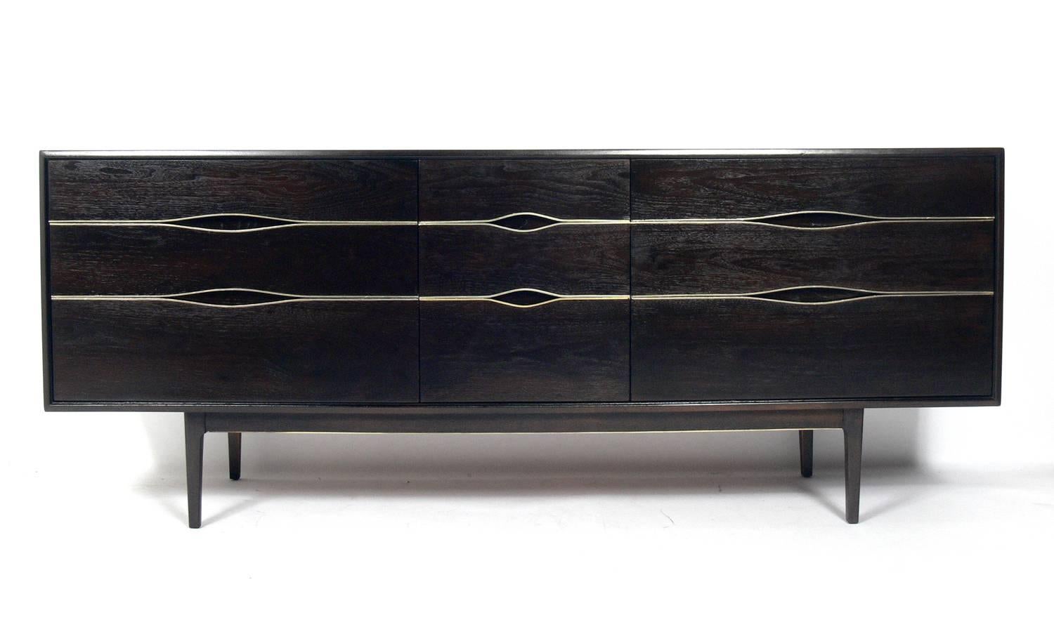 Ultra dark brown Mid-Century chest or dresser with brass trim, American, circa 1960s. This piece has been refinished in an ultra deep brown color and the brass trim has been hand polished and lacquered. It offers a voluminous amount of storage with