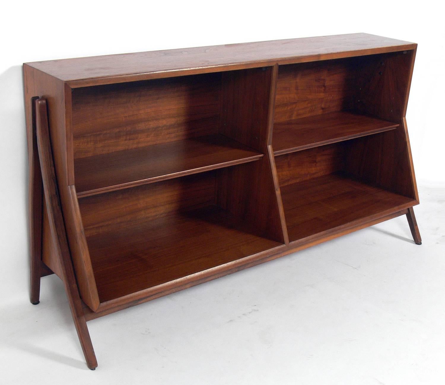 Sculptural bookshelf, designed by Kipp Stewart for Drexel, American, circa 1960s. This piece has a Danish Modern style with elegantly flared legs. It is a versatile size and would work as a bookshelf or case, credenza, vitrine, or bar.