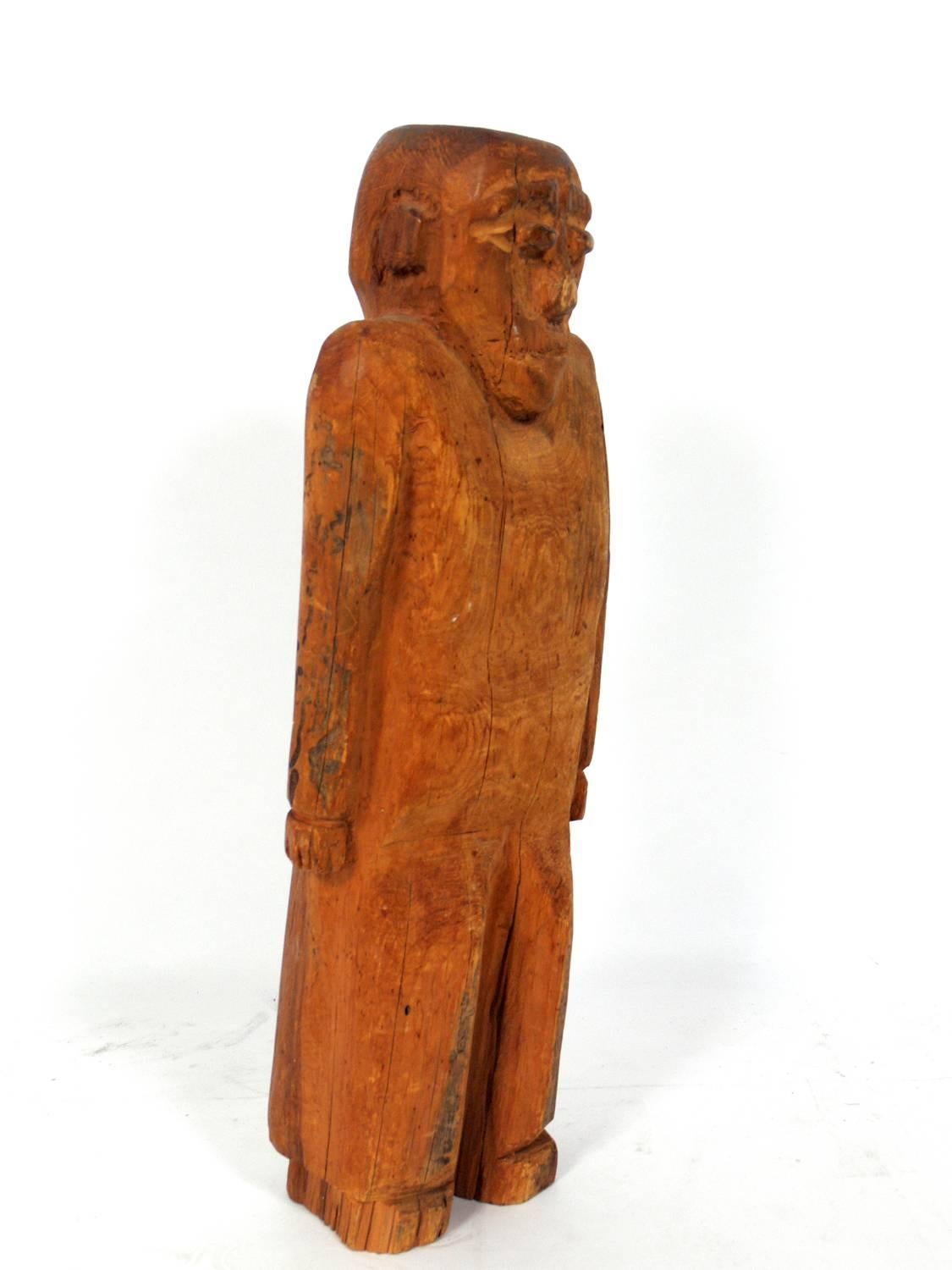 Hand-carved folk art man sculpture, American, believed to be circa 1940s. Playful shrugging form. Retains warm original patina.