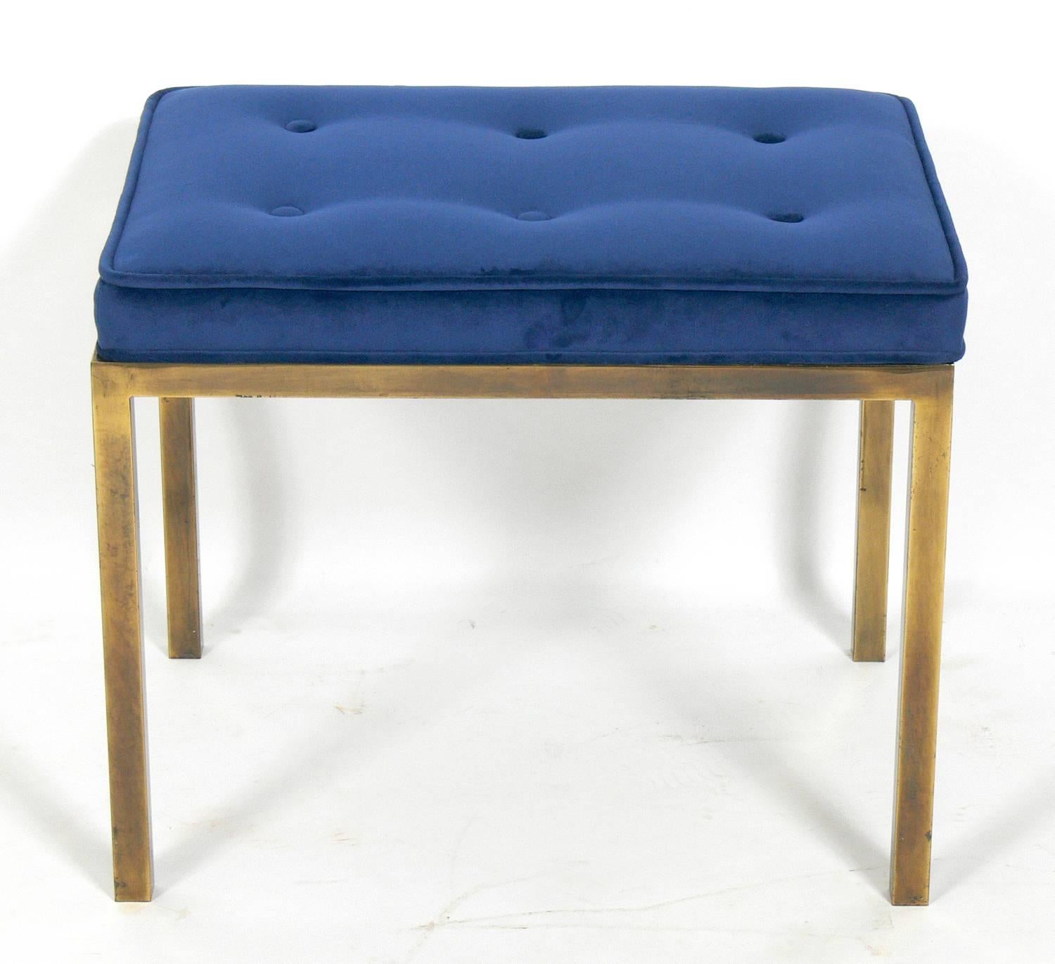 Clean lined brass bench, in the manner of Edward Wormley for Dunbar, American, circa 1960s. It has been reupholstered in an indigo blue color velvety fabric. Brass retains warm original distressed patina.